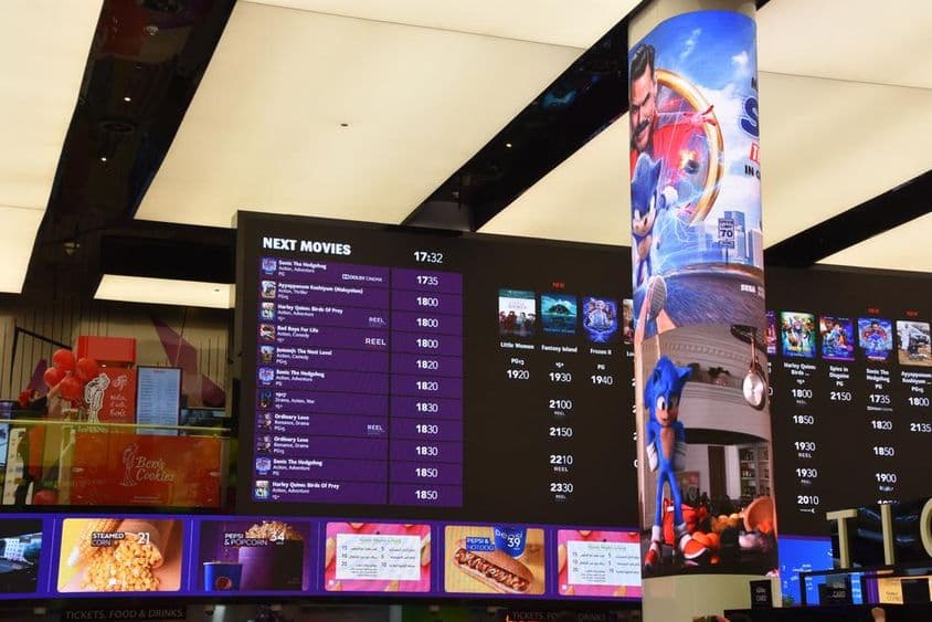 Cinema schedules displayed at Dubai Mall showing movie times and locations.