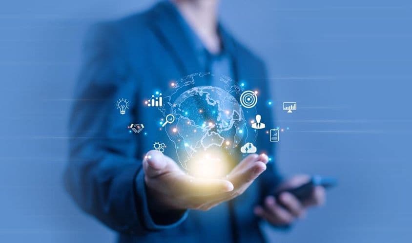 A person holding a globe-shaped digital projection.