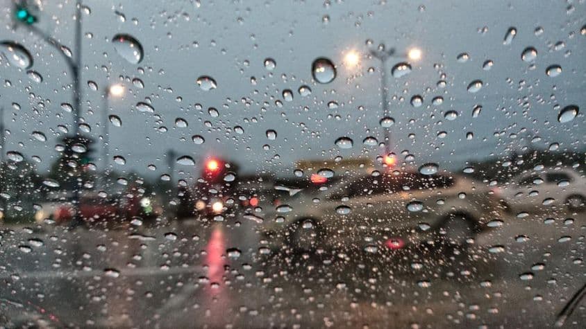 Cars appearing blurry through rain-covered glass.