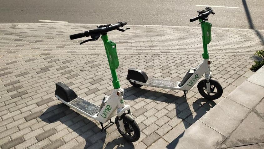 Lime scooters standing on a street in Dubai.