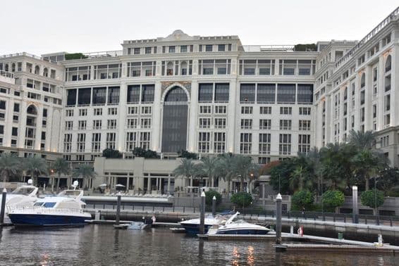 Dubai's Palazzo Versace hotel, with motorboats bobbing in the water nearby.