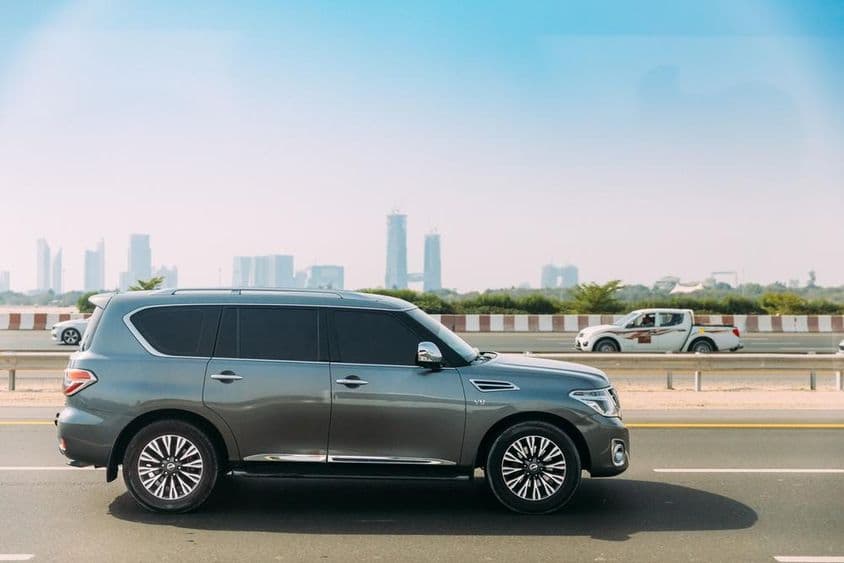 Nissan Patrol in the foreground with Dubai skyscrapers in the background.