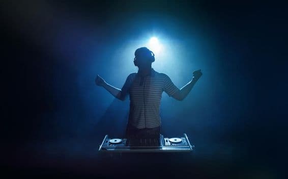 A person stands behind the DJ booth.