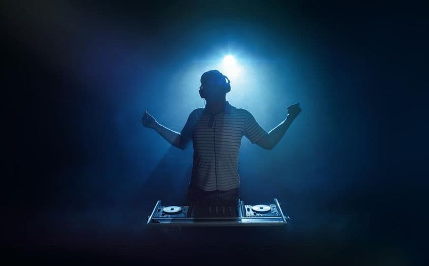 A person stands behind the DJ booth.