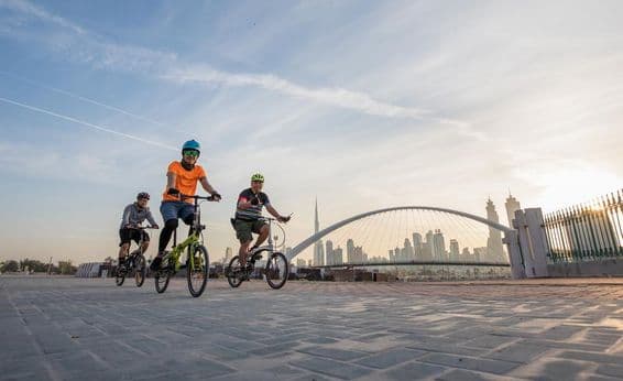 Cyclists with helmets in front of Burj Khalifa.