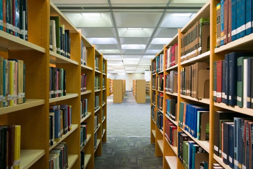 A library is visible with shelves containing books.