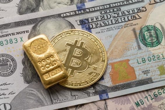 An investment gold bar and a Bitcoin coin over a 100 dollar bill.