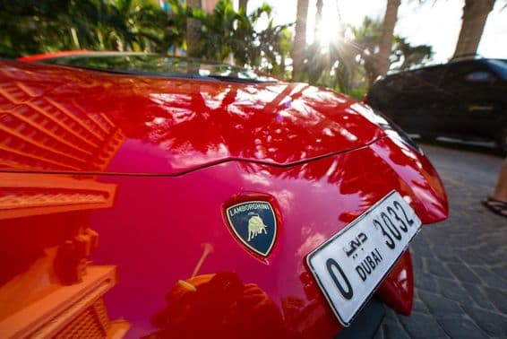 A red Lamborghini front, showing a four-digit Dubai license plate.
