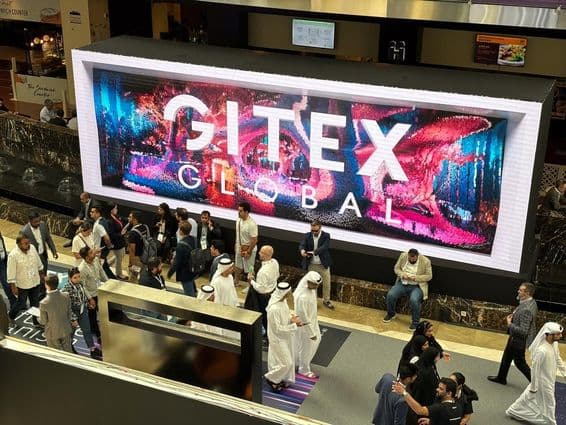 Gitex Global in the background with people, mainly Emirati men and women in the foreground.