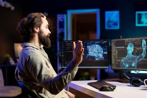 A developer coding AI program while greeting a human silhouette on the monitor.