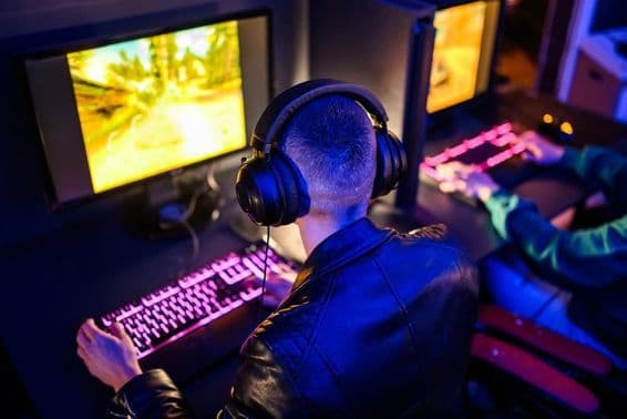 Online gamers visible, with illuminated keyboard and monitor in front.