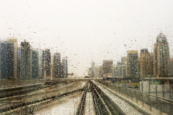 Rain-drenched window with a view of skyscrapers.