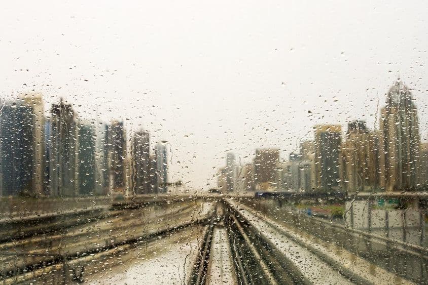 Rain-drenched window with a view of skyscrapers.