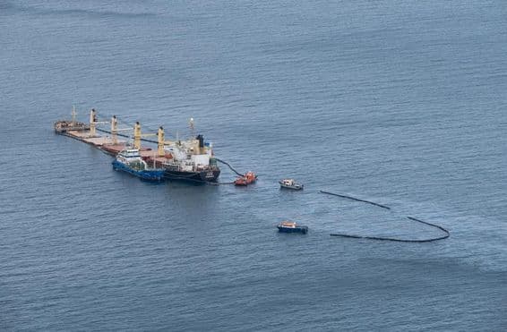 Cleaning oil spill at sea, boats surrounding area.
