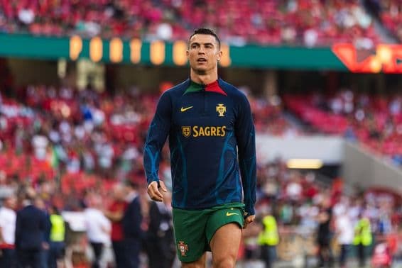 Cristiano Ronaldo on the field in a blue jersey with green shorts.