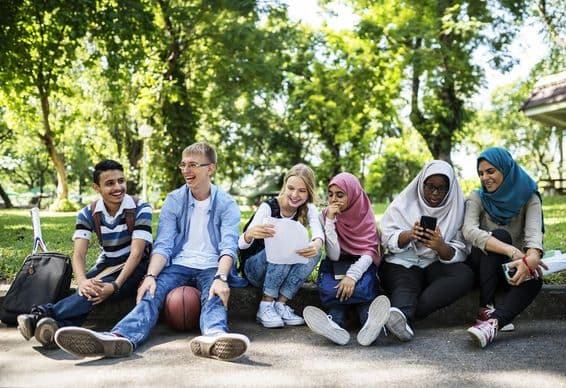 Dubai students sitting on a roadside.