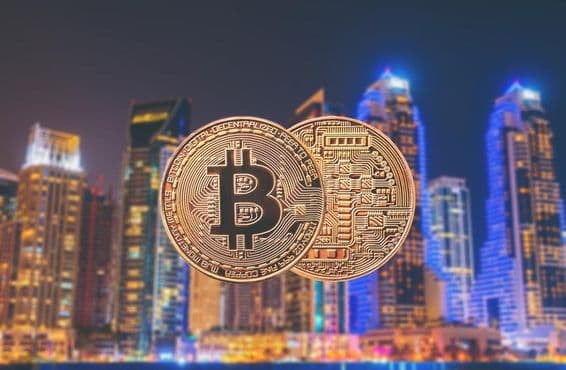 Bitcoin coins in the foreground with skyscrapers in the background.
