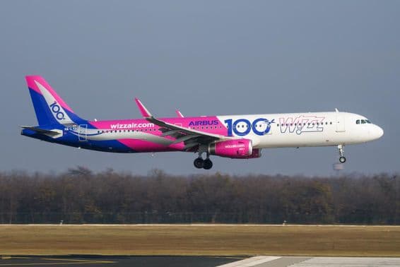 Wizz Air plane flying at low altitude over the runway.