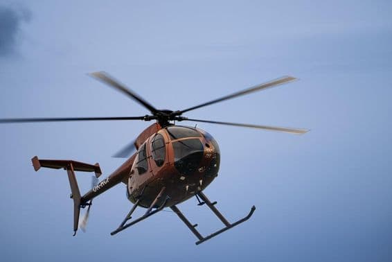 A lightweight helicopter flying in the air.