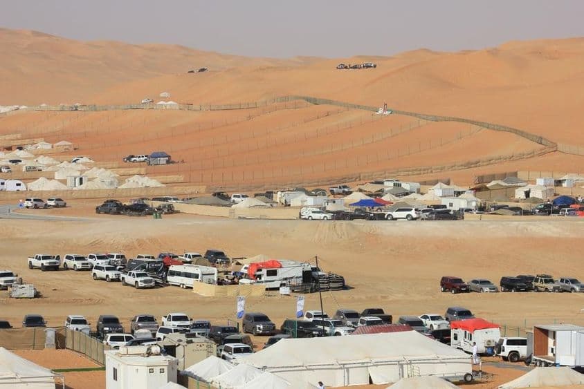 Liwa International Festival scenery in the desert with cars, RVs, and tents.