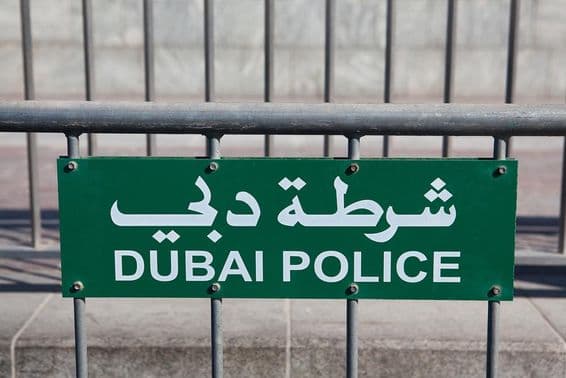 Dubai Police sign visible on a fence.