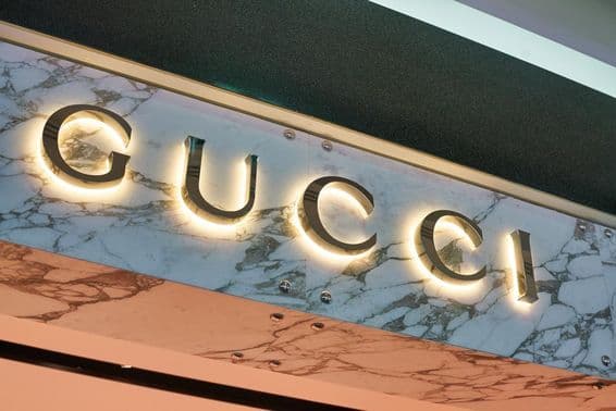 Gucci sign in illuminated letters on a wall facade.