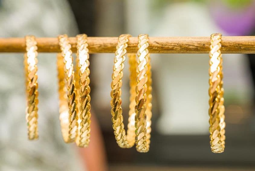 24-karat gold bracelets threaded onto a rod.