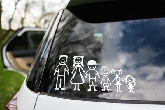 A car's rear window displays a sticker of a family, including 2 adults and 4 children.