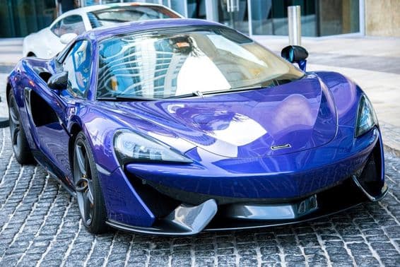 Blue McLaren car parked on a Dubai street.