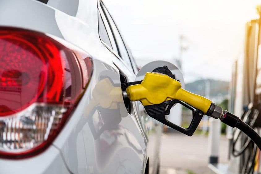 Fuel nozzle inserted into a car's filler opening.