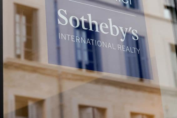 Sotheby's sign visible on the front of a building, on a transparent board.