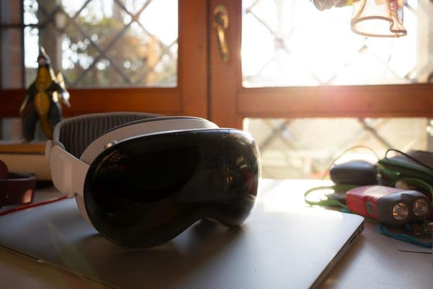 Apple Vision Pro lying on a notebook on a table.