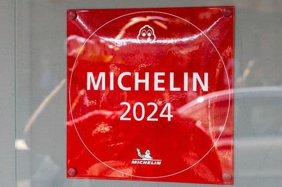 A Michelin Guide 2024 plaque seen on a restaurant wall.