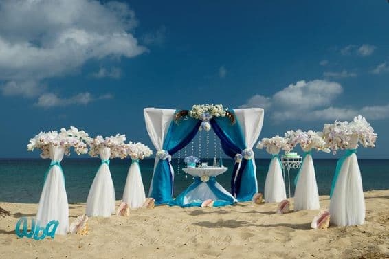 Beach wedding on sand with flowers and small table