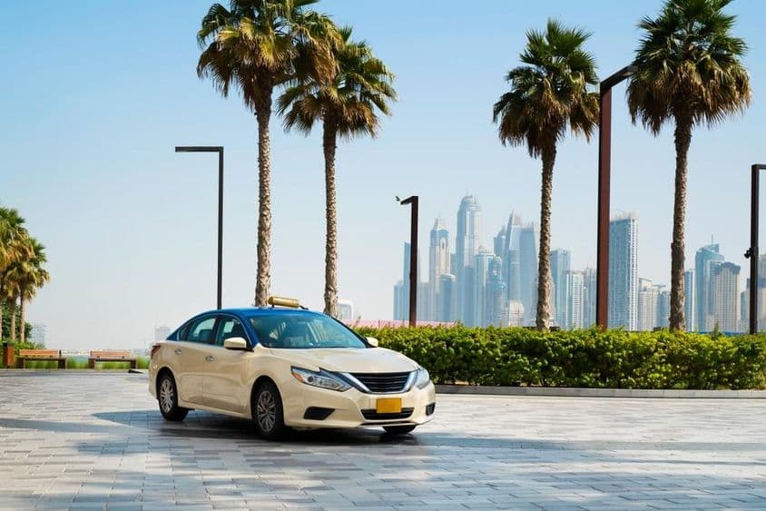 Dubai taxi with skyscrapers in the background.