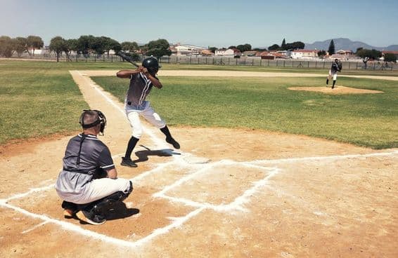 A baseball player waits for a pitch from the pitcher.