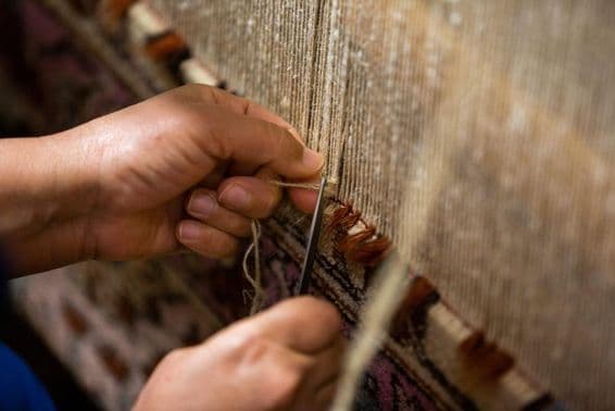Handmaking a Persian carpet.