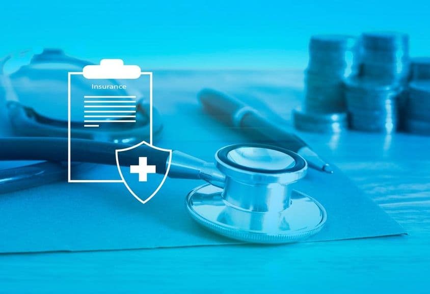 Health insurance foreground, background with a stethoscope and small change.