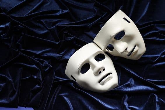 Theater, two white masks on blue velvet.