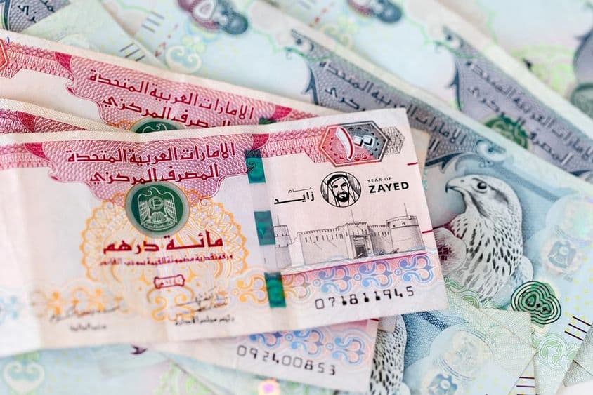 UAE dirham banknotes piled on top of each other.