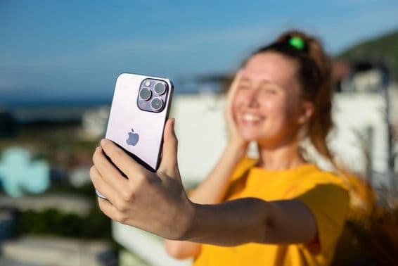 Young girl holding an iPhone phone.