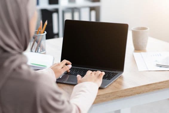Muslim woman working on a laptop.