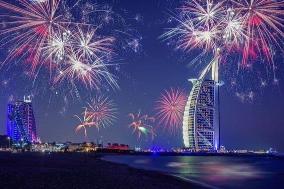 Dubai New Year's Eve with Burj Al Arab and fireworks in the background.