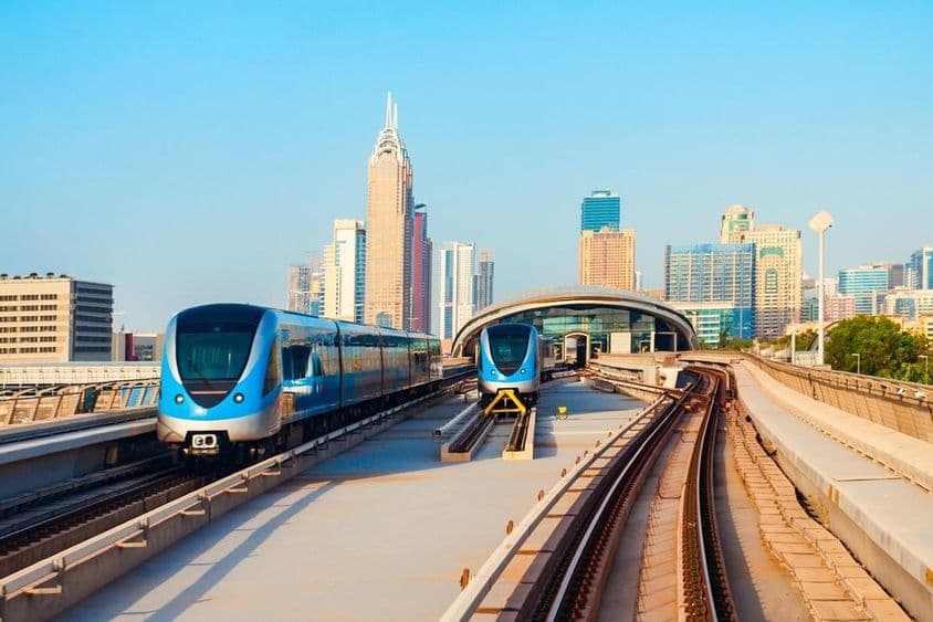 Dubai metro cars with skyscrapers in the background.
