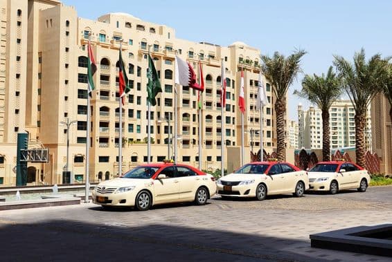Dubai taxis in front of a 10-story residential building.