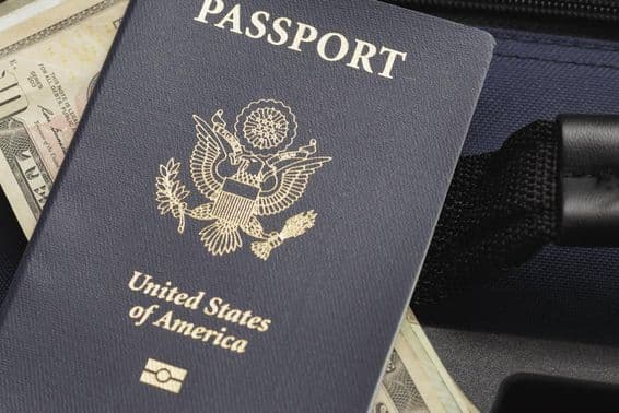 USA passport resting on dollars.