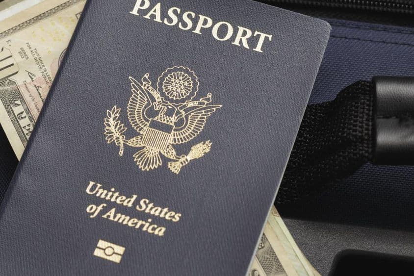 USA passport resting on dollars.