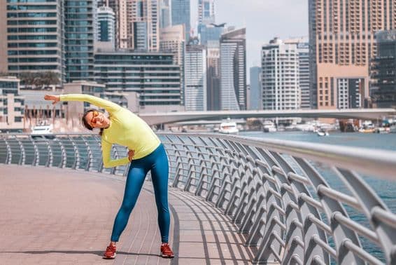 Dubai young girl stretching after a run at the Marina.
