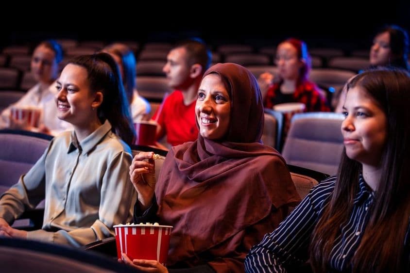 Muslim woman enjoying in cinema.