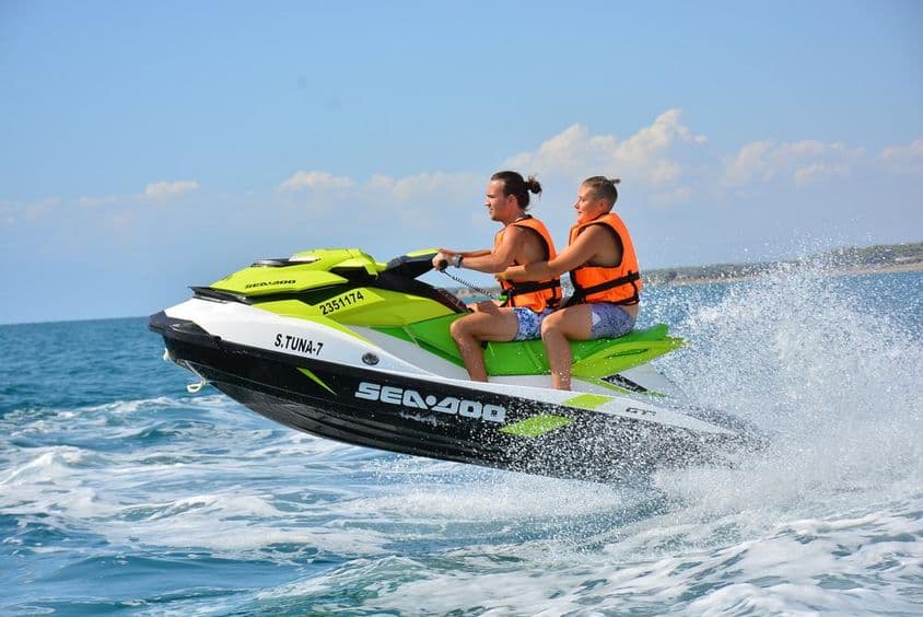 Young couple sitting on a jet ski.